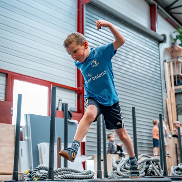 Enfant en plein saut sur un parcours moteur